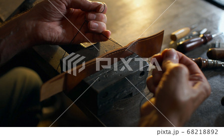 Artisan working with leather. Artisan working with leather. 68218892