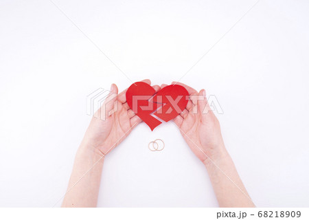 Female hands hold a broken heart on a white 68218909