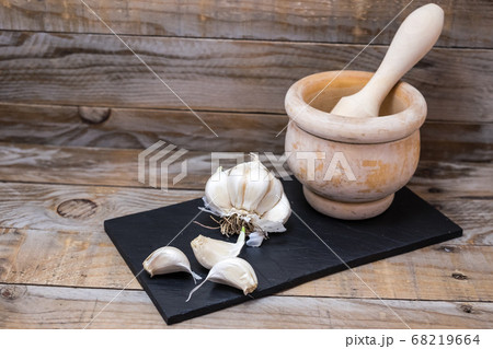 cooking ingredients and spices like garlic over a board to cut and prepare them for cooking 68219664