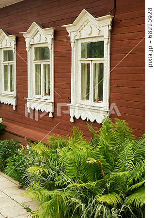Old wooden houses with beautiful windows.Frames with tiles.An old Russian house. 68220928