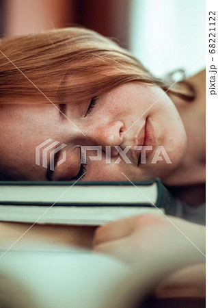 Ginger hair girl sleeping on stack of books. Tired Ginger hair girl sleeping on stack of books. Tired 68221122