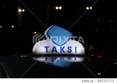 Taxi light sign or cab sign in blue and white color on the car roof at the street in the dark night. Taxi light sign or cab sign in blue and white color on the car roof at the street in the dark night. 68221773
