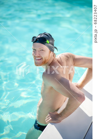 Satisfied man standing in water in pool Satisfied man standing in water in pool 68223407