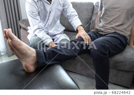 Doctor physiotherapist treating leg pain patient 68224642