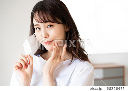 朝マスクをつけようとする若い女性 朝マスクをつけようとする若い女性 68226475