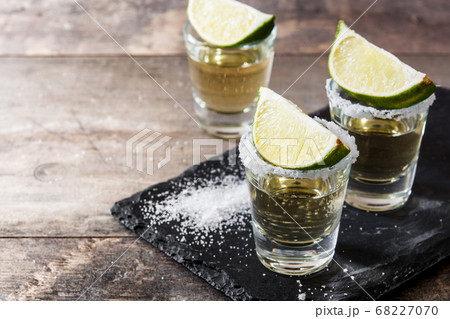 Mexican Gold tequila with lime and salt on wooden table. Mexican Gold tequila with lime and salt on wooden table. 68227070