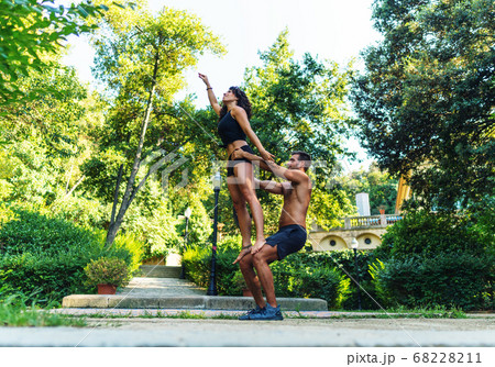 Beautiful man and woman doing acroyoga in the garden or park 68228211