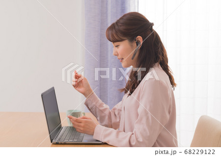 テレワークでノートPCを使ってWEB会議する若い女性 68229122