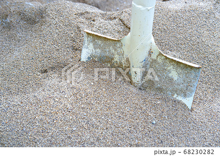 Steel shovel in the sand at the construction site. 68230282