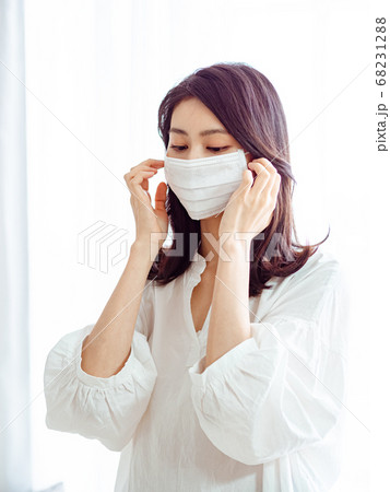 Young asian woman wearing Surgical mask to prevent 68231288