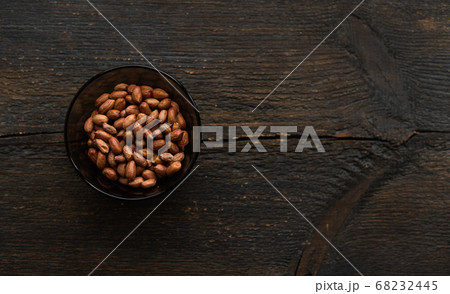 Peanut nuts in a small plate on a vintage wooden table. Peanuts nut is a healthy vegetarian protein nutritious food. 68232445