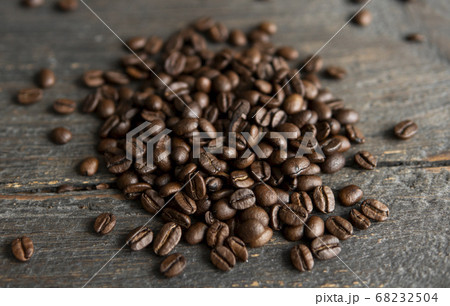 Roasted arabica coffee beans scattered on a wooden table. Fresh coffee beans. 68232504