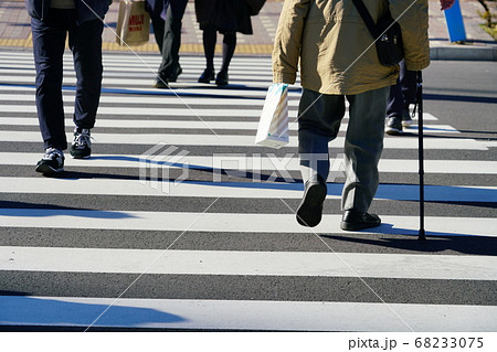 横断歩道を歩く老人と若者の後ろ姿 68233075