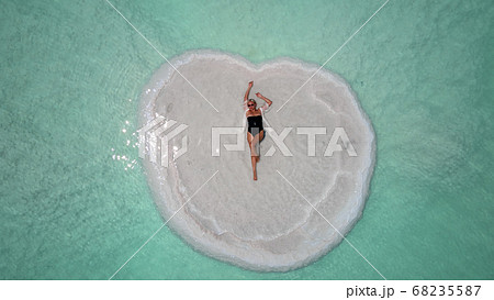 Journey to the shores of the Dead Sea. Shooting from the drone. bather relaxing on an island in the Dead Sea 68235587