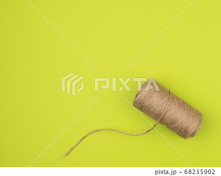 Coil of jute rope on a green background. Coil of jute rope on a green background. 68235902