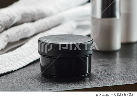 cosmetic black jar on a black table hair gel, bathroom .mocap, close up, copy space horizontal orientation 68236702