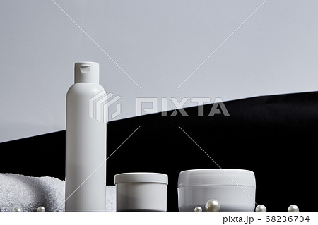 white cosmetic jars for the bath a long tube of pearl towel on a gray and black background. copy space. mockup. bot view 68236704