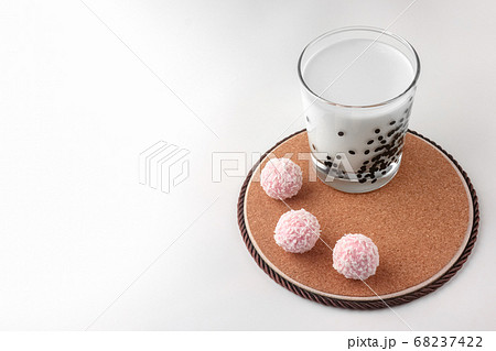 pink chocolate candy and a glass of milk on a white background. candy ball macro. isolate pink chocolate candy and a glass of milk on a white background. candy ball macro. isolate 68237422