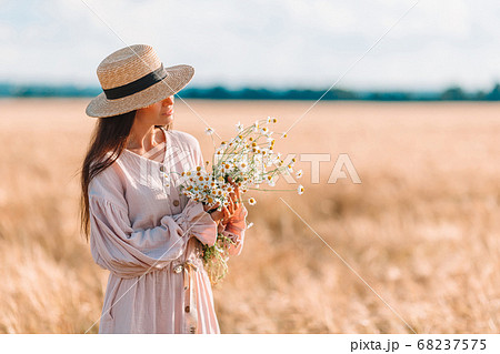 Beautiful girl in wheat field with ripe wheat in hands 68237575