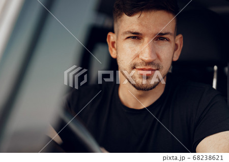 Handsome young man driver looking through the window of his off-road car Handsome young man driver looking through the window of his off-road car 68238621