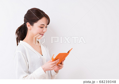 手帳を見てスケジュールを確認するビジネスウーマン 68239348