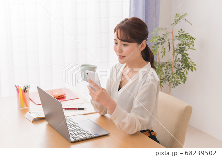 自宅でノートPCを使ってテレワークするビジネスウーマン 68239502