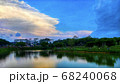 Lake view with clear water surrounded by trees under a blue sky 68240068