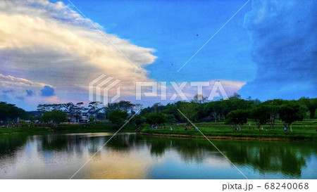 Lake view with clear water surrounded by trees under a blue sky Lake view with clear water surrounded by trees under a blue sky 68240068
