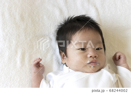口元にミルクのついた生後一か月の赤ちゃんの写真素材