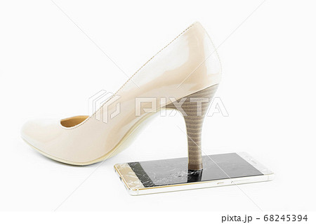 High heels are stepping on a broken glass mobile phone screen isolated on white background 68245394
