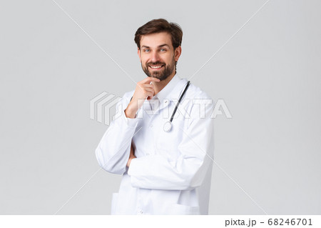 Hospital, healthcare workers, covid-19 treatment concept. Talented doctor in white scrubs with stethoscope, rubbing chin and look with curiosity or interest, listening to patient symptoms Hospital, healthcare workers, covid-19 treatment concept. Talented doctor in white scrubs with stethoscope, rubbing chin and look with curiosity or interest, listening to patient symptoms 68246701