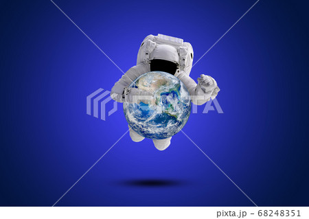 Blue planet earth in hand of Astronaut flying over blue background. Blue planet earth in hand of Astronaut flying over blue background. 68248351