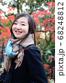 紅葉の前でポーズをとる女性 68248812