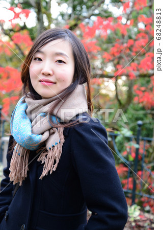 紅葉の前でポーズをとる女性 68248813