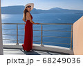 young woman enjoying view of Santorini, Greece 68249036