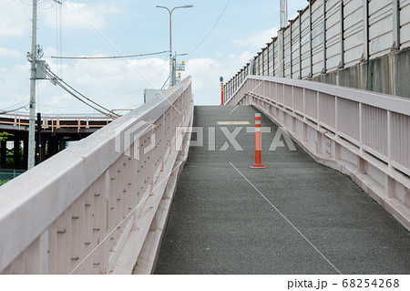 川を越える登り坂の歩道の真ん中に設置されたセンターポール 横構図の写真素材