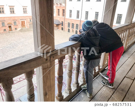 Young children, boys stand on a wooden old balcony Young children, boys stand on a wooden old balcony 68257531