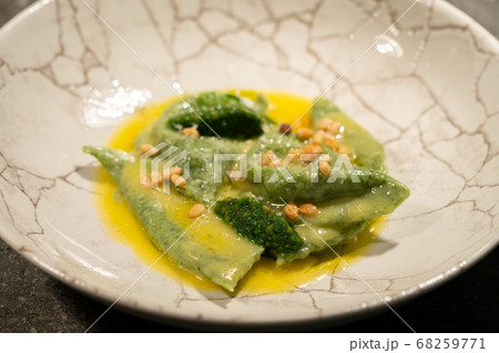 green ravioli with spinach and nuts in a plate 68259771