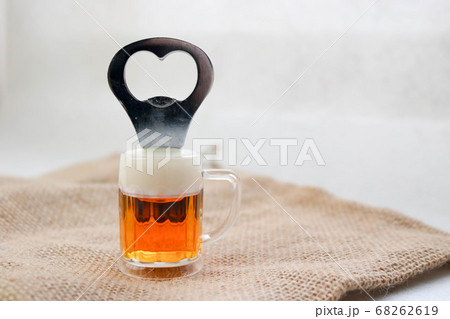 A yellow bottle opener in the form of a glass 68262619
