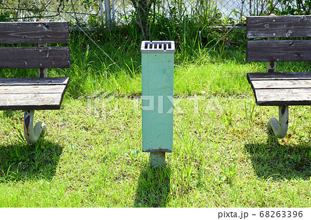 公園の喫煙所　木製ベンチと灰皿 68263396