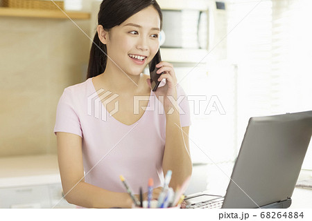Business woman working at home with her laptop and smartphone Business woman working at home with her laptop and smartphone 68264884