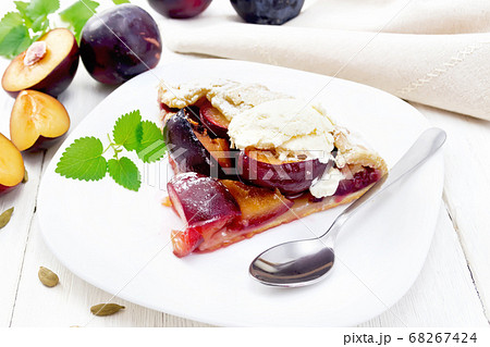 Galeta with plums in plate on wooden table 68267424