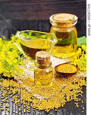 Oil mustard in two jars and gravy boat on dark 68267709
