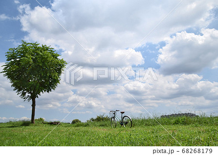 1本の木、青空と雲、地平線、静かにたずむ自転車。 1本の木、青空と雲、地平線、静かにたずむ自転車。 68268179