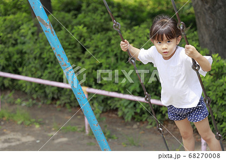 ブランコで立ちこぎをする幼児 5歳児 の写真素材