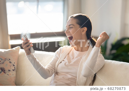 Overjoyed young girl looking at mobile screen, making yes gesture. Overjoyed young girl looking at mobile screen, making yes gesture. 68270873