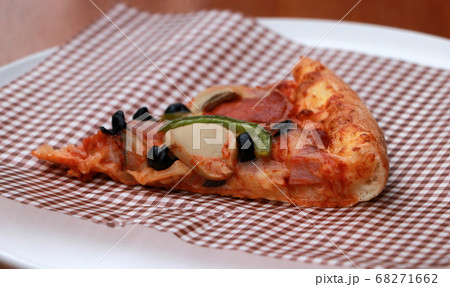 A piece of triangle Pizza  place on brown scotch paper. 68271662