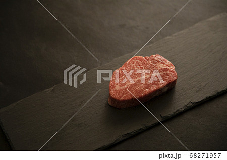 黒スレートプレートに乗せた生の肉厚牛フィレステーキ 68271957