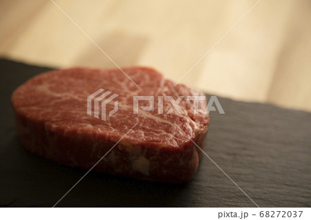 黒スレートプレートに乗せた生の肉厚牛フィレステーキ 68272037