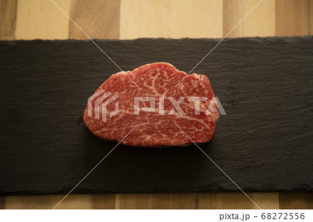 木の机の上の黒スレートに乗せた生の肉厚牛フィレステーキ 木の机の上の黒スレートに乗せた生の肉厚牛フィレステーキ 68272556